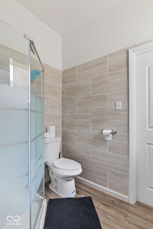 938 N Tuxedo St, Indianapolis, IN 46201 - full bathroom featuring a shower stall, toilet, tile walls, and wood finished floors