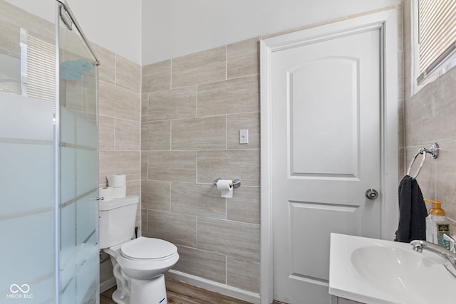 938 N Tuxedo St, Indianapolis, IN 46201 - bathroom featuring tile walls, a stall shower, toilet, and vanity