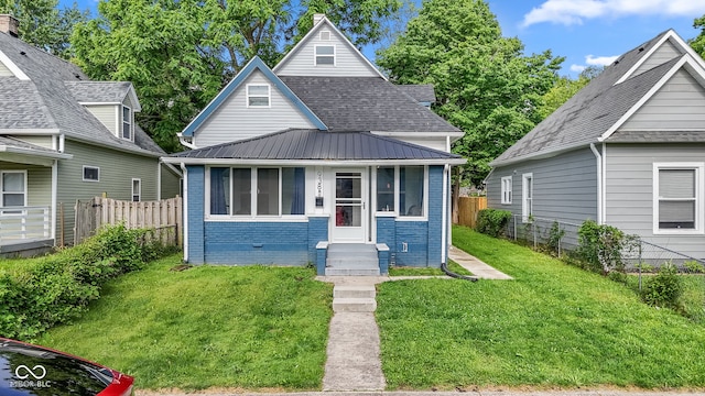 938 N Tuxedo St, Indianapolis, IN 46201 - view of front of home featuring entry steps, brick siding, and metal roof