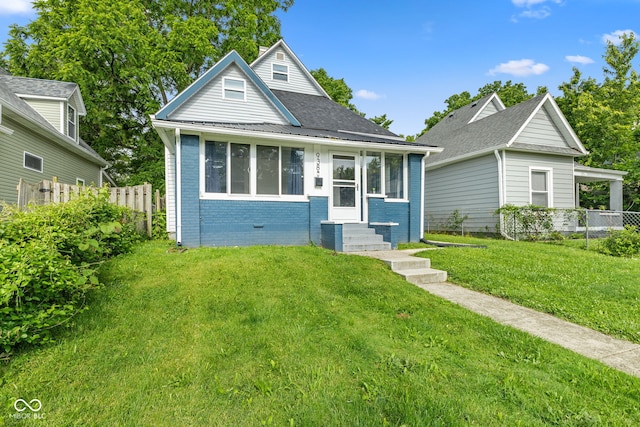 938 N Tuxedo St, Indianapolis, IN 46201 - bungalow with entry steps, brick siding, and a shingled roof