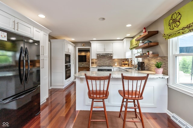 3713 Coventry Way, Carmel, IN 46033 - kitchen featuring black appliances, dark wood-style flooring, tasteful backsplash, a peninsula, and a sink