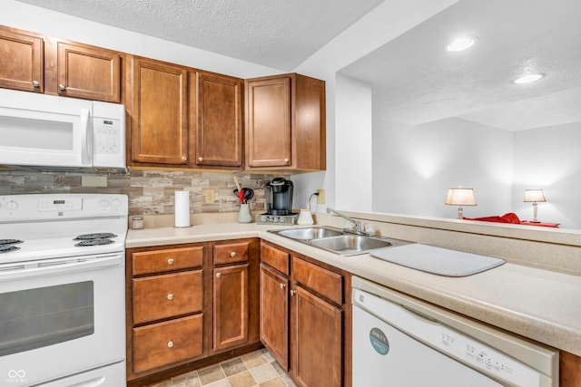 517 E Graham Pl, Bloomington, IN 47401 - kitchen with white appliances, a sink, a textured ceiling, light countertops, and brown cabinetry