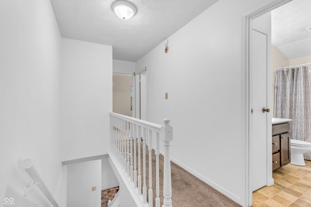 517 E Graham Pl, Bloomington, IN 47401 - hall with an upstairs landing, a textured ceiling, and baseboards