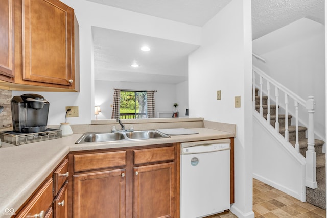 517 E Graham Pl, Bloomington, IN 47401 - kitchen with white dishwasher, a sink, light countertops, brown cabinetry, and recessed lighting