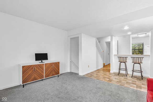 517 E Graham Pl, Bloomington, IN 47401 - unfurnished living room featuring carpet floors, stairs, baseboards, and recessed lighting