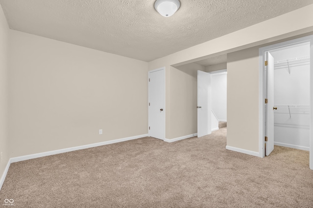 517 E Graham Pl, Bloomington, IN 47401 - unfurnished bedroom featuring carpet floors, a textured ceiling, baseboards, a closet, and a spacious closet