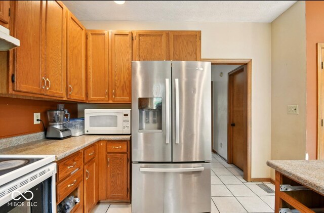 6396 Granny Smith Ln, Avon, IN 46123 - kitchen with stainless steel refrigerator with ice dispenser, white microwave, light countertops, and light tile patterned flooring
