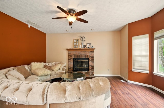 6396 Granny Smith Ln, Avon, IN 46123 - living area with ceiling fan, baseboards, wood finished floors, a fireplace, and a textured ceiling
