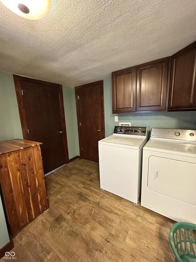12967 N County Road 825 E, Roachdale, IN 46172 - laundry area featuring cabinet space, washer and clothes dryer, wood finished floors, and a textured ceiling