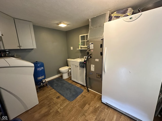 12967 N County Road 825 E, Roachdale, IN 46172 - laundry area featuring washer / clothes dryer, wood finished floors, a textured ceiling, a sink, and baseboards