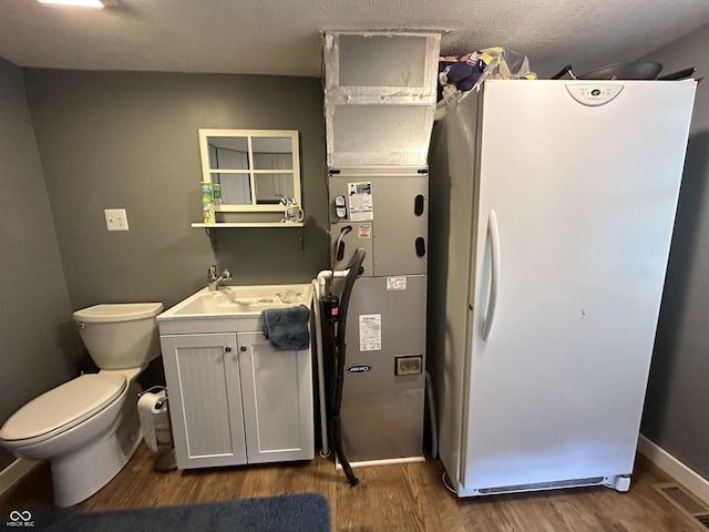 12967 N County Road 825 E, Roachdale, IN 46172 - kitchen with freestanding refrigerator, wood finished floors, a sink, and baseboards