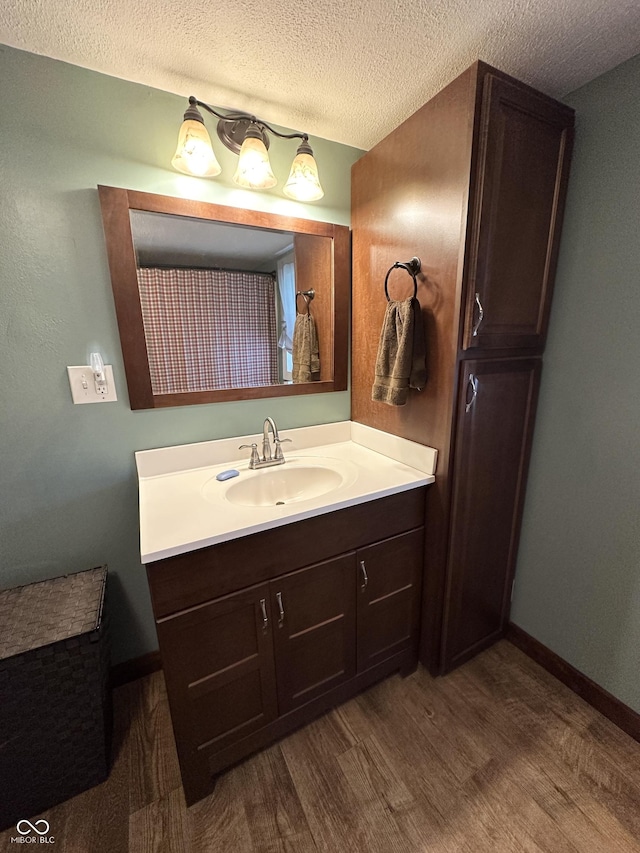 12967 N County Road 825 E, Roachdale, IN 46172 - full bathroom with wood finished floors, vanity, a textured ceiling, and baseboards