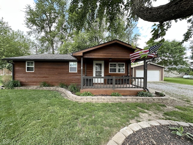 12967 N County Road 825 E, Roachdale, IN 46172 - view of front of house featuring a porch, a front yard, an outdoor structure, and a garage