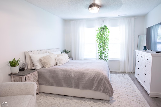2210 Bridlewood Dr, Franklin, IN 46131 - bedroom with multiple windows, light wood-type flooring, and a textured ceiling