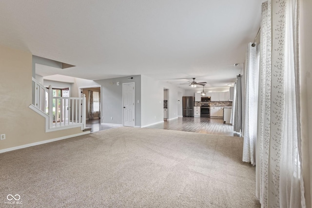 5852 Long Ridge Pl, Indianapolis, IN 46221 - unfurnished living room with carpet, baseboards, ceiling fan, and stairs