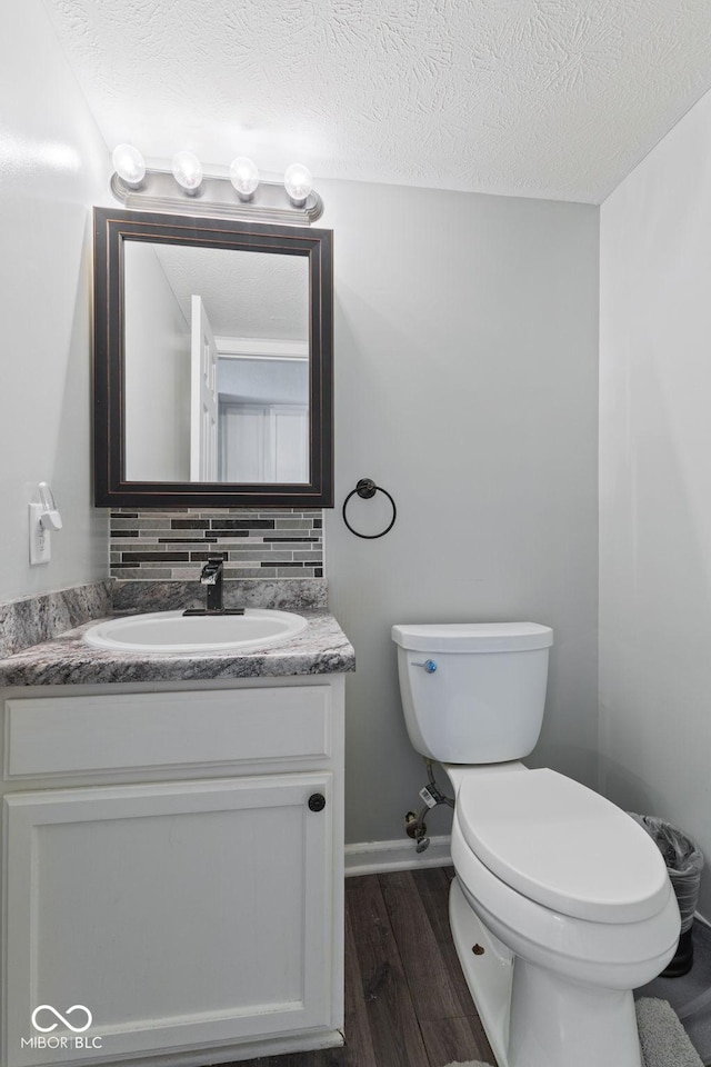5852 Long Ridge Pl, Indianapolis, IN 46221 - bathroom featuring vanity, wood finished floors, toilet, baseboards, and a textured ceiling