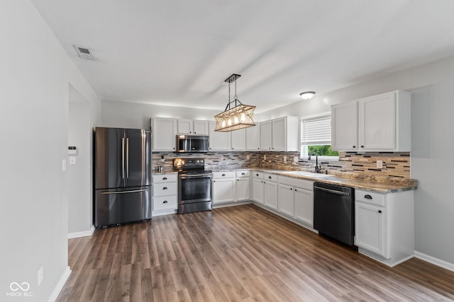 5852 Long Ridge Pl, Indianapolis, IN 46221 - kitchen with appliances with stainless steel finishes, a sink, decorative backsplash, dark wood finished floors, and baseboards