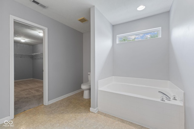 5852 Long Ridge Pl, Indianapolis, IN 46221 - bathroom featuring a garden tub, toilet, a spacious closet, and baseboards