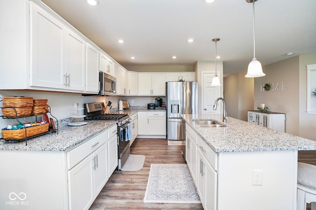 7184 Lillian Pl, Cumberland, IN 46229 - kitchen with stainless steel appliances, a sink, light wood-style floors, white cabinetry, and recessed lighting