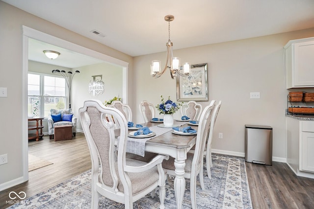7184 Lillian Pl, Cumberland, IN 46229 - dining room with wood finished floors, a chandelier, and baseboards
