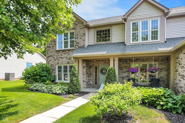 10965 Fairway Ridge Ln, Fishers, IN 46037 - view of front of house featuring brick siding, a front lawn, a porch, and central air condition unit