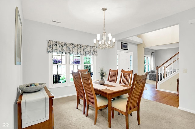 10965 Fairway Ridge Ln, Fishers, IN 46037 - carpeted dining room with plenty of natural light, a chandelier, stairs, and baseboards