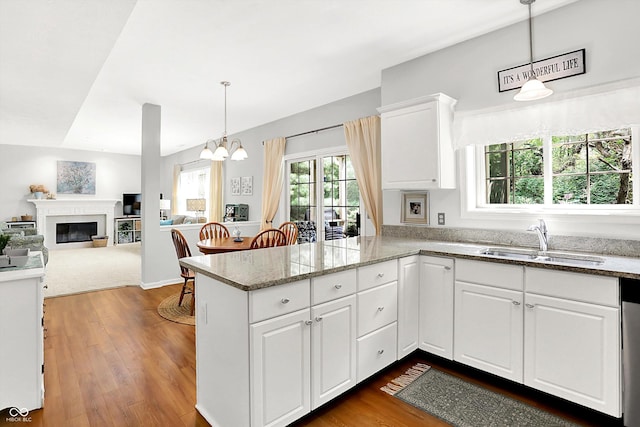 10965 Fairway Ridge Ln, Fishers, IN 46037 - kitchen with a sink, a peninsula, white cabinetry, a chandelier, and light stone countertops
