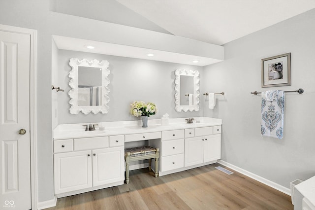 10965 Fairway Ridge Ln, Fishers, IN 46037 - bathroom with double vanity, baseboards, wood finished floors, recessed lighting, and lofted ceiling