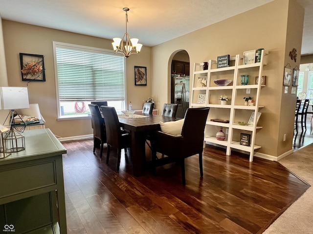1518 Valdarno Dr, Greenwood, IN 46143 - dining area featuring arched walkways, healthy amount of natural light, a chandelier, and dark wood-style flooring