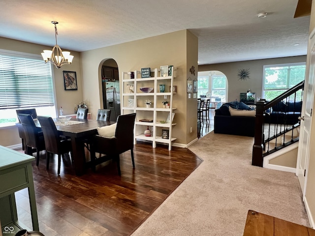 1518 Valdarno Dr, Greenwood, IN 46143 - dining room with arched walkways, wood finished floors, a chandelier, baseboards, and stairway