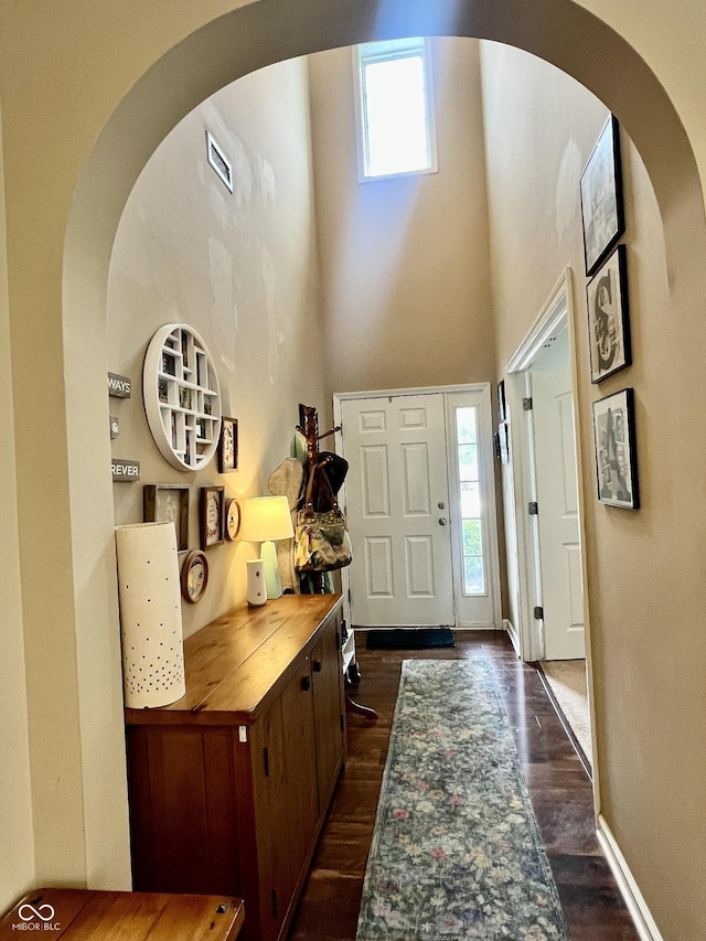 1518 Valdarno Dr, Greenwood, IN 46143 - entrance foyer with dark wood finished floors, baseboards, a towering ceiling, and arched walkways