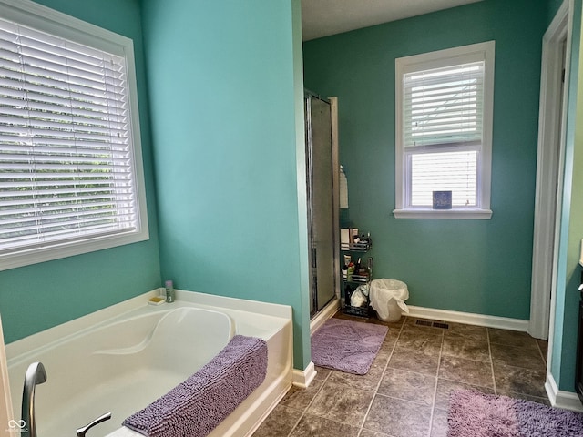 1518 Valdarno Dr, Greenwood, IN 46143 - bathroom with healthy amount of natural light, a bath, a shower stall, and baseboards