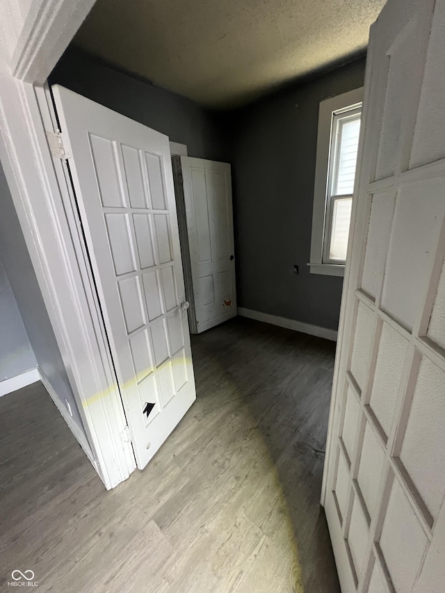 409 Parkway Ave, Indianapolis, IN 46225 - unfurnished bedroom featuring baseboards, wood finished floors, and a textured ceiling
