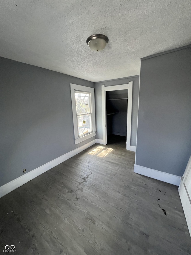 409 Parkway Ave, Indianapolis, IN 46225 - unfurnished bedroom featuring baseboards, a textured ceiling, wood finished floors, and a closet