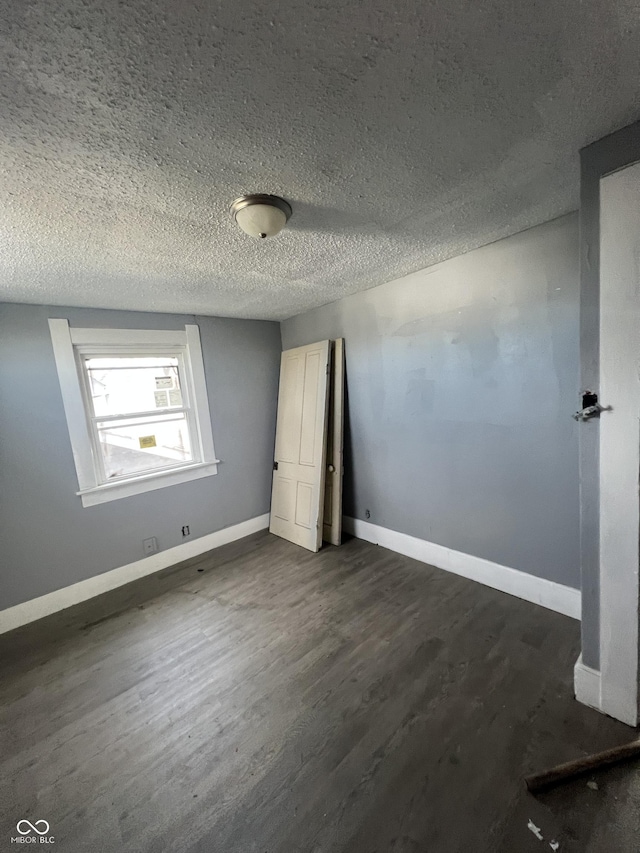 409 Parkway Ave, Indianapolis, IN 46225 - unfurnished bedroom with dark wood-style floors, baseboards, and a textured ceiling