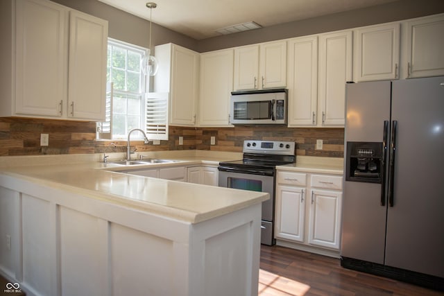 kitchen with stainless steel appliances, a sink, white cabinets, decorative backsplash, and decorative light fixtures