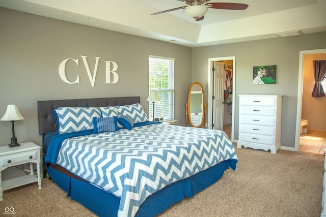 carpeted bedroom featuring a spacious closet, a closet, connected bathroom, baseboards, and ceiling fan