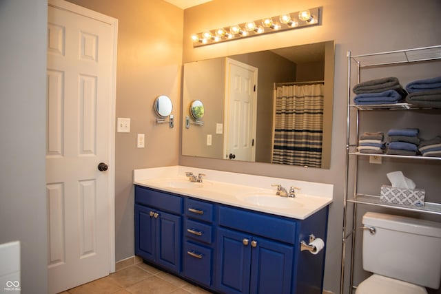 bathroom featuring double vanity, tile patterned floors, and toilet