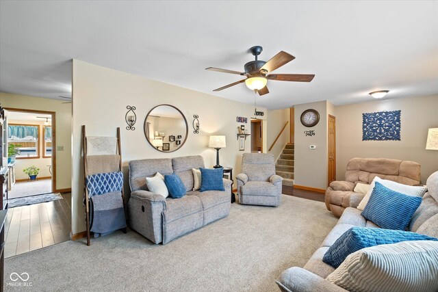 580 Northgate Dr, Greenwood, IN 46143 - carpeted living area featuring stairway, a ceiling fan, baseboards, and wood finished floors