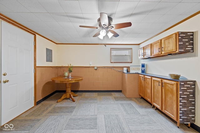 580 Northgate Dr, Greenwood, IN 46143 - kitchen with electric panel, a ceiling fan, ornamental molding, a wainscoted wall, and tile walls