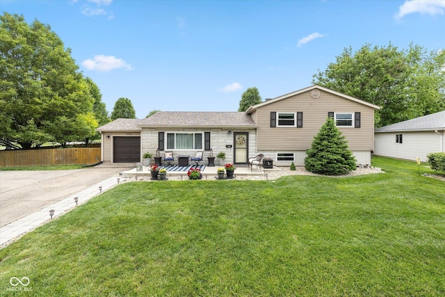 580 Northgate Dr, Greenwood, IN 46143 - split level home with concrete driveway, an attached garage, stone siding, and roof with shingles