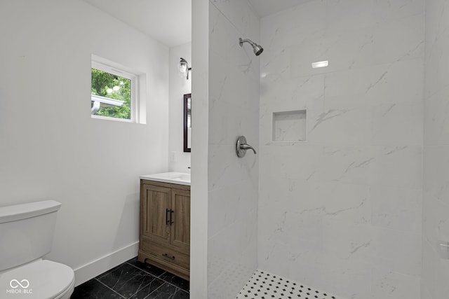 1411 N Grant Ave, Indianapolis, IN 46201 - full bathroom with marble finish flooring, vanity, toilet, baseboards, and a tile shower