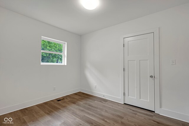 1411 N Grant Ave, Indianapolis, IN 46201 - spare room featuring baseboards and wood finished floors
