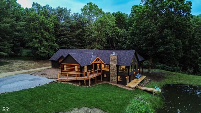 3463 Plum Creek Rd, Nashville, IN 47448 - back of house featuring a yard, a wooden deck, a chimney, a shingled roof, and stone siding