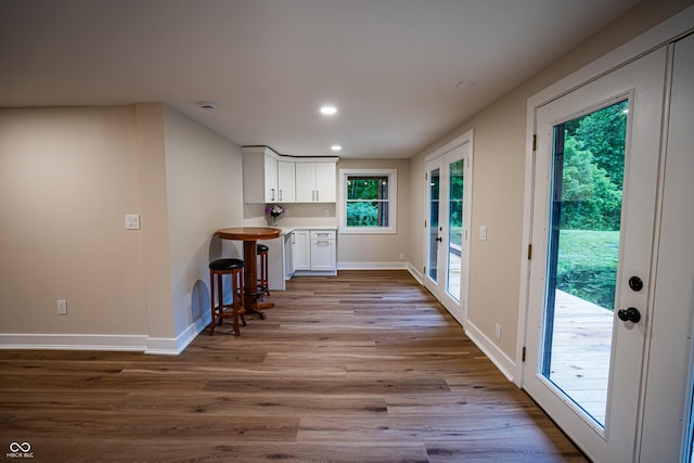 3463 Plum Creek Rd, Nashville, IN 47448 - kitchen featuring wood finished floors, white cabinets, baseboards, recessed lighting, and a kitchen breakfast bar