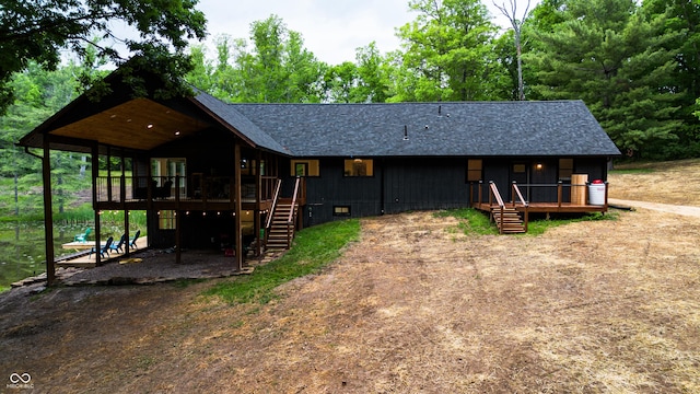 3463 Plum Creek Rd, Nashville, IN 47448 - view of front facade featuring stairs, a wooden deck, and a shingled roof