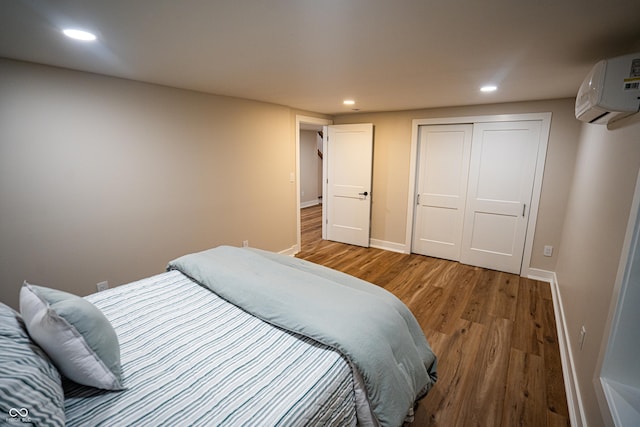 3463 Plum Creek Rd, Nashville, IN 47448 - bedroom with a wall unit AC, light wood-style flooring, recessed lighting, baseboards, and a closet