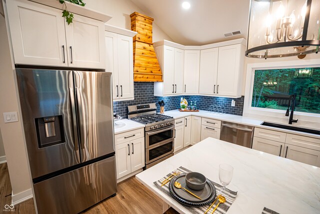 3463 Plum Creek Rd, Nashville, IN 47448 - kitchen with appliances with stainless steel finishes, a sink, decorative backsplash, light wood finished floors, and white cabinets