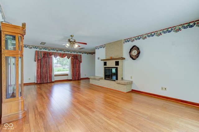 132 S First St, Jamestown, IN 46147 - unfurnished living room with light wood-type flooring, a ceiling fan, baseboards, and a brick fireplace