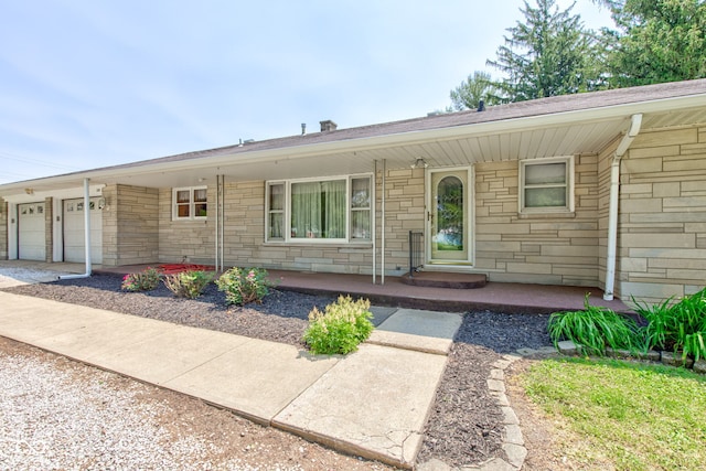132 S First St, Jamestown, IN 46147 - ranch-style house with stone siding, a garage, concrete driveway, and a porch